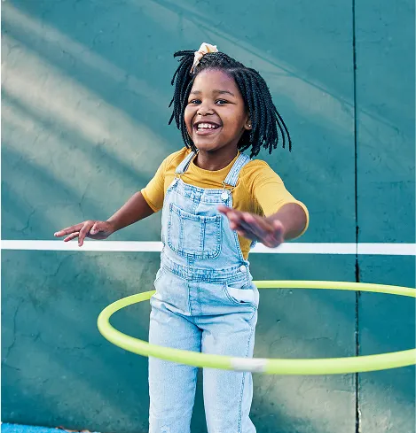 Student using a hula hoop on a play ground