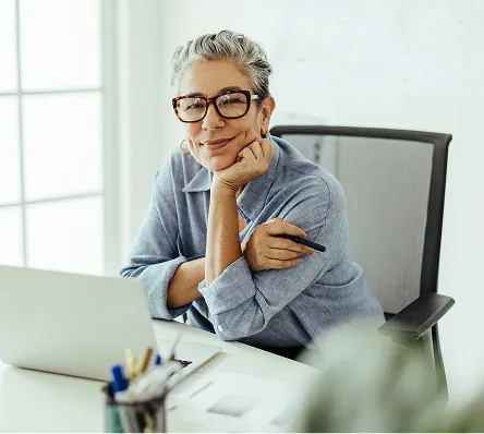 Teacher sitting at desk smiling