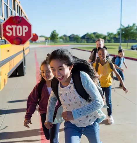Kids running happily to get on thier school bus