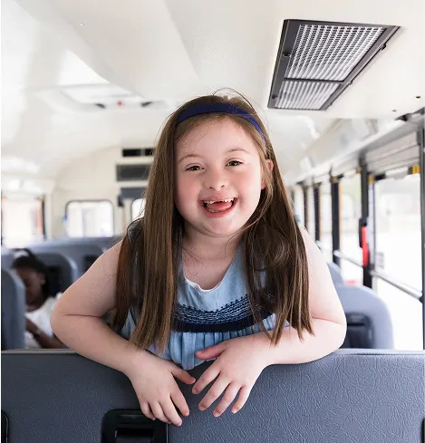 Student riding on the back of a school bus.
