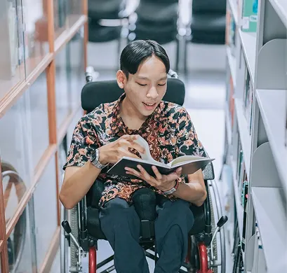 Student in a wheelchair reading a book